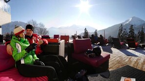 Un lounge en la azotea con asientos exteriores y vistas a la montaña.