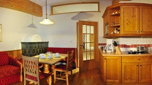 Una cocina acogedora con armarios de madera, una mesa de comedor con sillas y un banco empotrado.