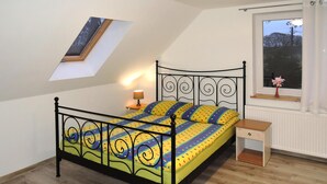 A single bed with a metal frame, a bedside table, a window with a view, and a skylight. - Holiday Flat in Kolczewo-70 qm for 6 Persons (gmina Wolin)