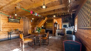 A rustic wooden interior with a dining area, staircase, and fireplace. - Holiday Home in Belczna Near Klepnicko Lake (Łobez)
