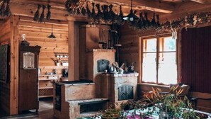 A rustic wooden cabin interior with a fireplace, wooden beams, and a dining area. - Holiday Home in Belczna Near Klepnicko Lake (Łobez)