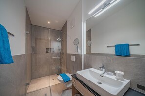 Une salle de bain moderne équipée d’une douche, de toilettes et d’un lavabo.