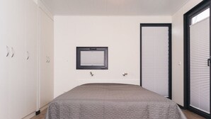 A bedroom with a bed, a window, a door, and a wardrobe. - Hausboot in Boltenhagen (Boltenhagen)