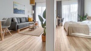 Una habitación de hotel moderna con sofá, mesa de comedor y cama.