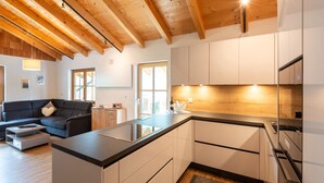 A modern kitchen with wooden beams, a central island, and white cabinetry.