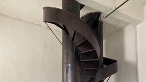 A spiral staircase with a metallic finish, ascending to an upper level. - Luxury 1 BDR Loft: Near State Fair w/ Rooftop Pool (Dallas)