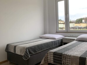 A small room with two beds, a window, and a view of the outside. - Holiday Home in Lazy by Seaside Beach (gmina Sianów)