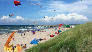 A beach with tents, a grassy area, and a view of the sea. - Single-story Holiday Homes Close to the Beach (gmina Sianów)