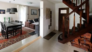 A spacious living area with a dining table, sofa, and staircase. - Holiday Home in Lukecin Near Baltic Beach (Dziwnów)