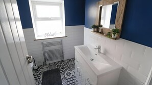 Un bagno con una vasca da bagno bianca, una finestra e uno specchio a parete.