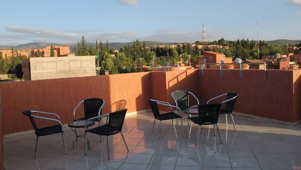 Eine Dachterrasse mit Stühlen und Blick auf die Stadt.