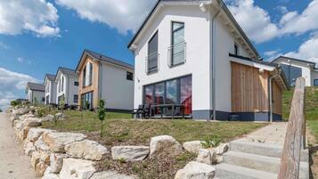 Situated on a well-maintained lawn, this residence features a clean design with large windows and a balcony.