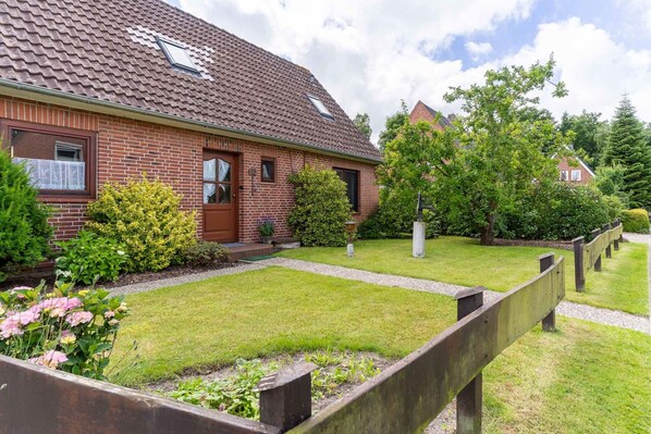 Traditional home with a lawn and mature trees.