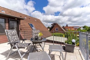 Enjoy the view from this balcony with lounge chairs and a small table.