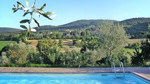 Una piscina con vista su un villaggio collinare.
