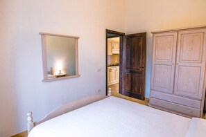 Une chambre à coucher avec un lit, un miroir et une armoire.