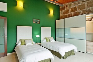 A hotel room with two beds, a green wall, a wooden ceiling, and a wardrobe with hanging clothes. - Dream Villa With Pool in Ingenio (Ingenio)
