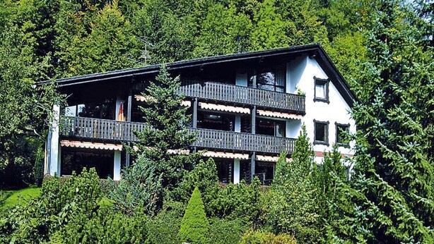 A multi-story building with balconies, surrounded by lush greenery and large rocks. - Ferienwohnung im Haus Schiefertal, Wieda (Walkenried)