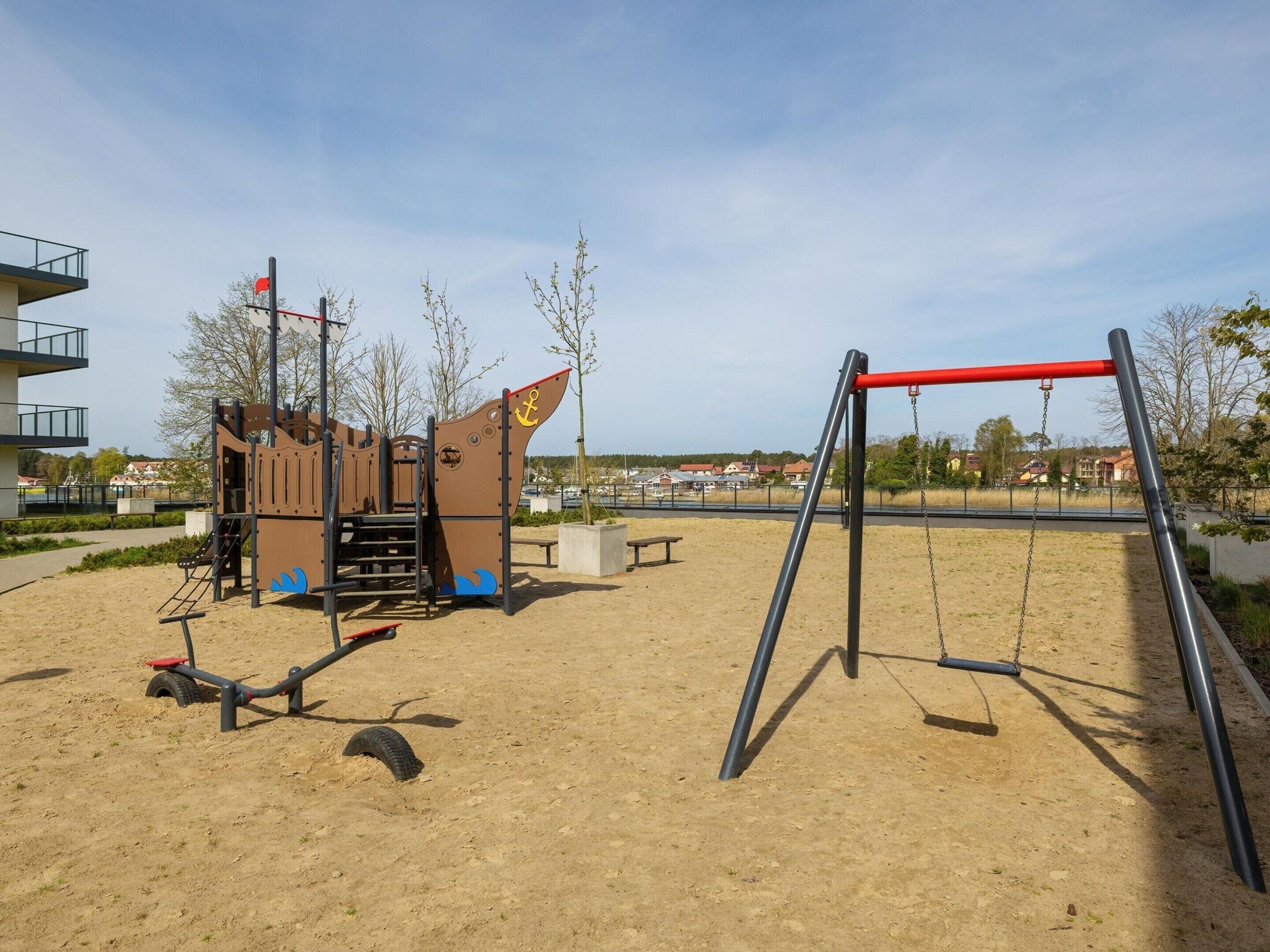 Un parque infantil con columpios y una estructura para escalar.