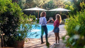 Two people standing by a pool with umbrellas and potted plants. - Resort Riva Degli Etruschi, San Vincenzo (San Vincenzo)