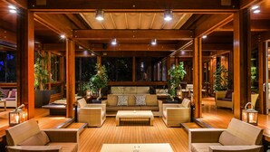 A spacious indoor area with wooden flooring, a central sofa, and multiple seating arrangements. - Resort Riva Degli Etruschi, San Vincenzo (San Vincenzo)