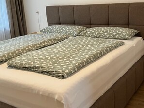 A bed with a headboard and two pillows with a geometric pattern. - Apartment in Axams Near Axamer Lizum (Axams)