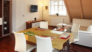 Un comedor con una mesa, sillas, un televisor y una ventana con vistas.