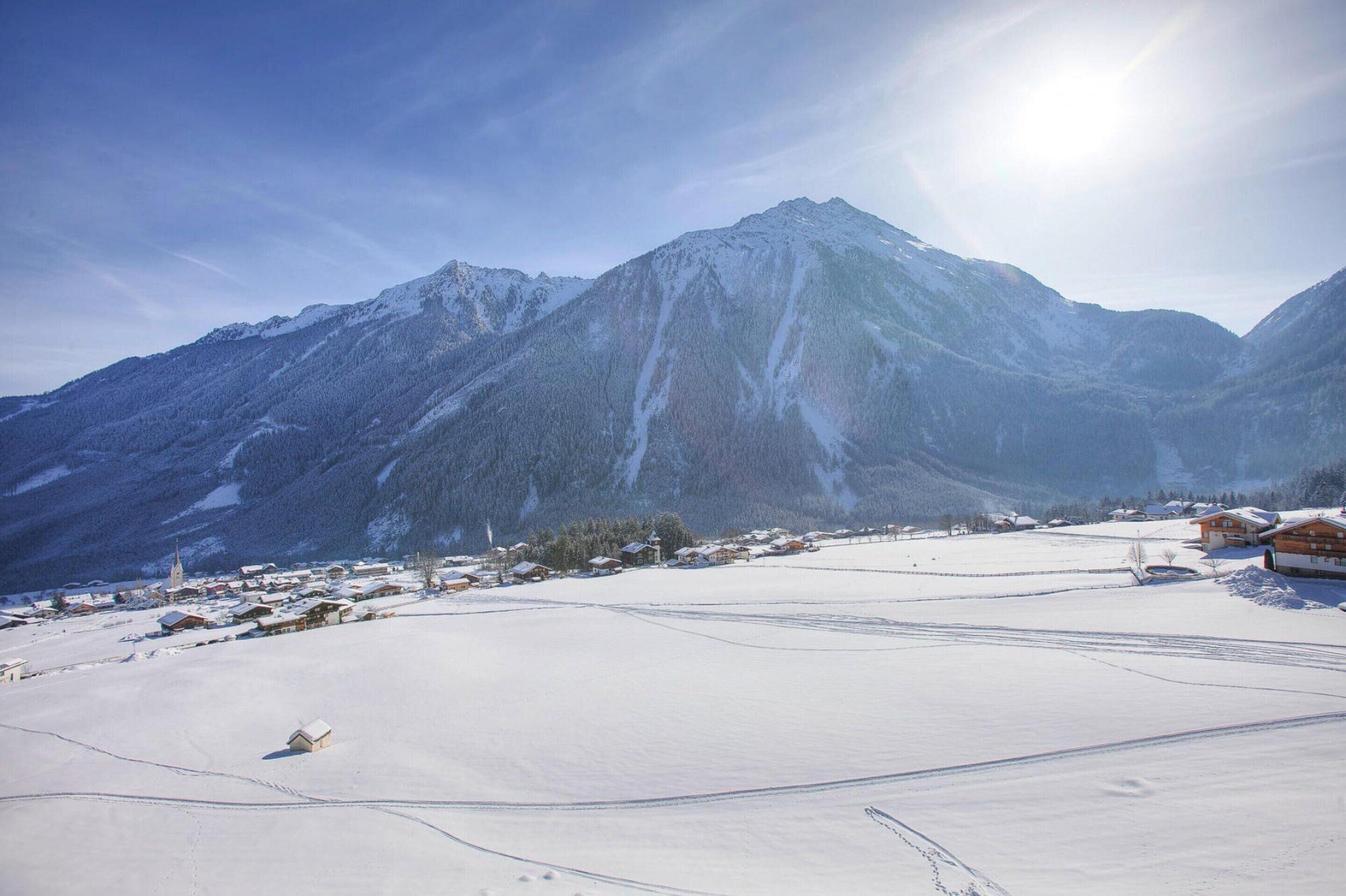 A snow-covered mountain landscape with a small village and houses.