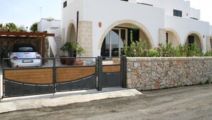 A modern white building with arched windows and a stone wall. - Apartments, Nardo (Nardò)