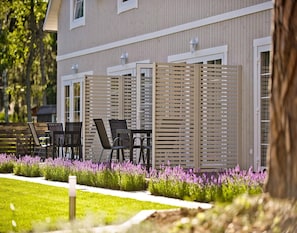 A modern outdoor seating area with a wooden fence, a table, and chairs. - Holiday Home Pobierowo Near Baltic Beach (Rewal)