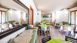 Un restaurante con varias mesas, sillas y una barra con menús.