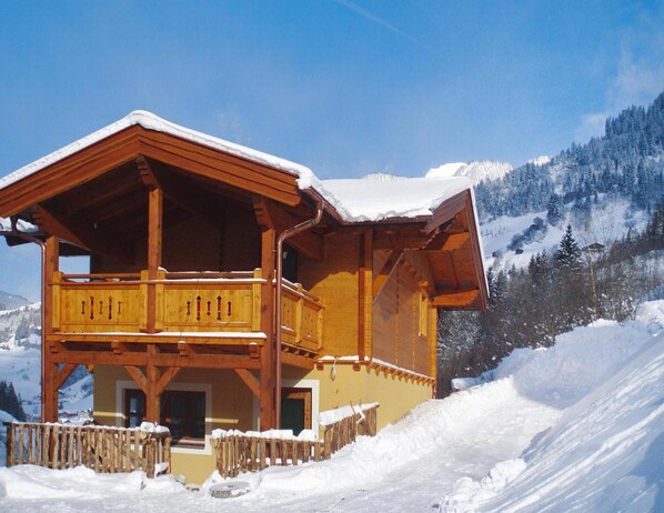A wooden chalet with a balcony, surrounded by snow-covered mountains. - Holiday Home in Grossarl With Mountain Views (Grossarl)