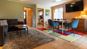 A cozy living area with a sofa, coffee table, and a TV mounted on the wall. - Doppelhaushalfte in Hasselfelde (Oberharz am Brocken)