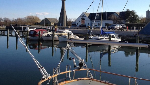 A marina with boats docked, a tall chimney, and a building with a sign. - Studio, Wyk auf Fohr (Wyk auf Foehr)