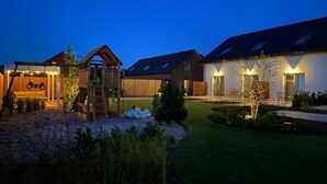 Ett bostadsområde med hus, en lekställning i trä och en välskött gräsmatta.