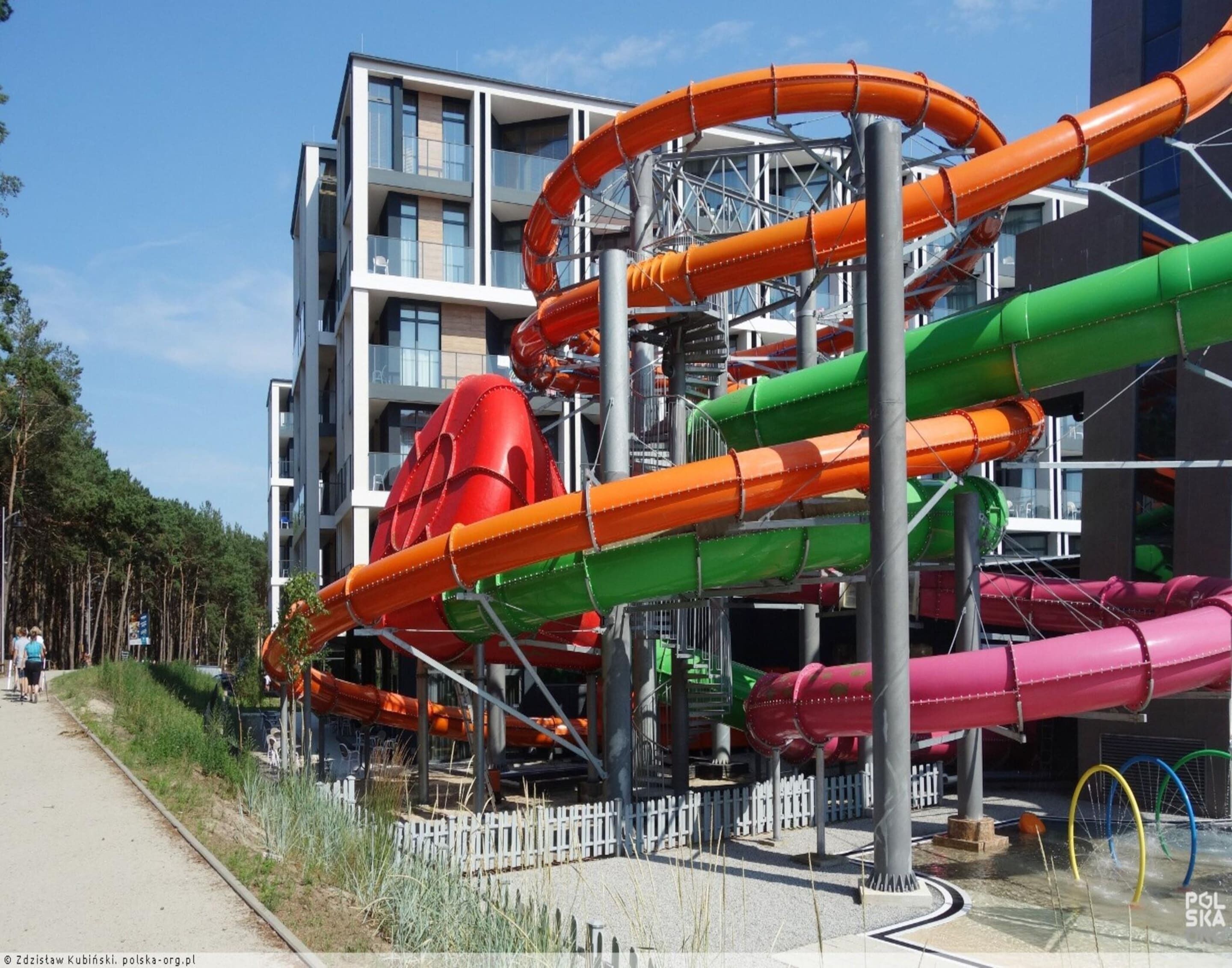 Ein Wasserpark mit mehreren Rutschen und einem Gebäude im Hintergrund.