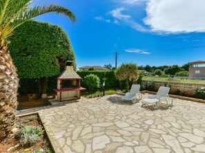 A patio with stone flooring, a barbecue grill, and two white lounge chairs. - Apartment on Vir Island Near Sandy Beaches (Vir)