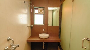 Une salle de bain équipée d’un lavabo, d’un miroir et d’un porte-serviettes.