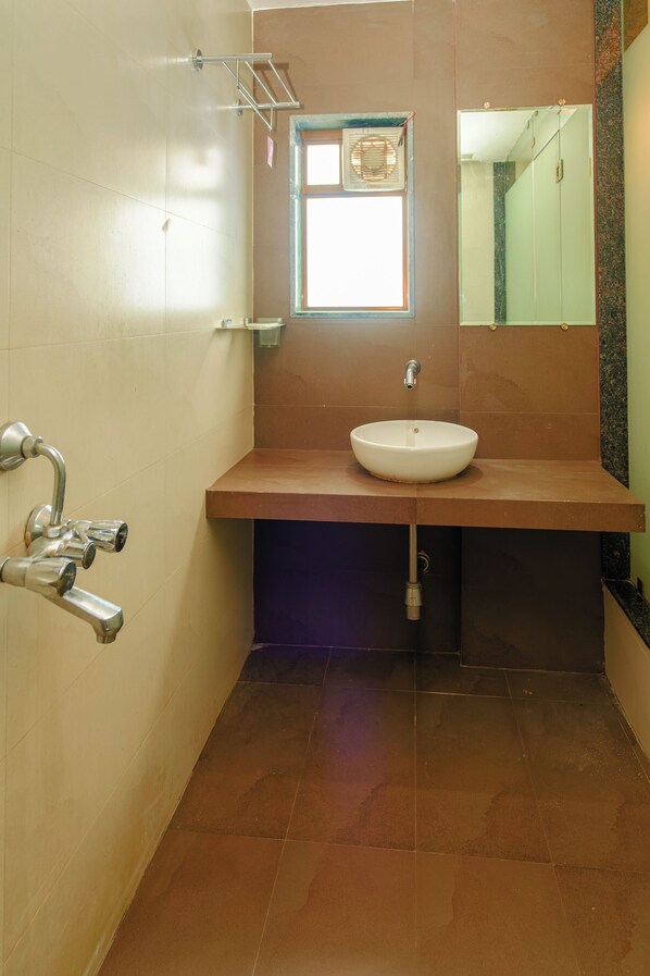 A bathroom with a white sink, a mirror, and a window.