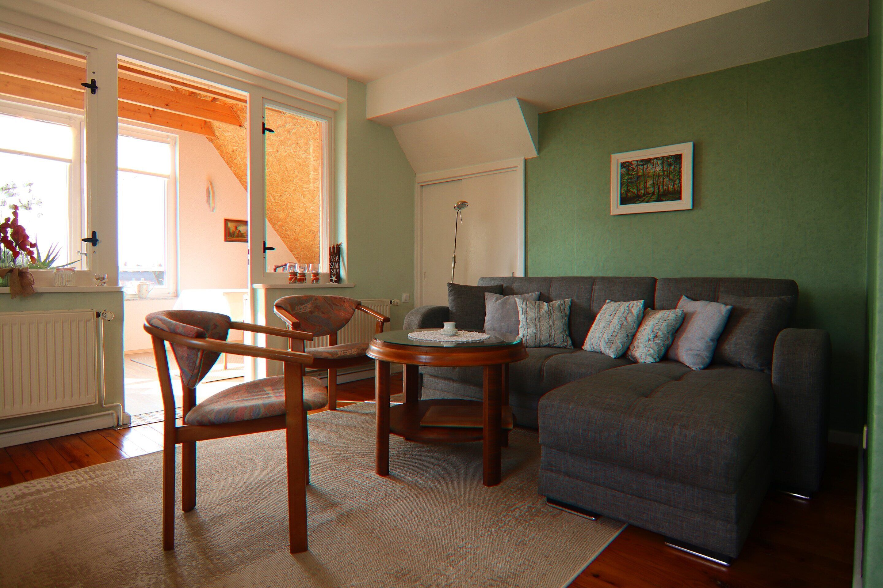 A living room with a sofa, two chairs, a coffee table, and a painting on the wall.