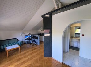 A compact living space with a kitchenette, a sofa, a dining area, and a bathroom with a vanity. - Holiday Home in Stepnica (Stepnica)