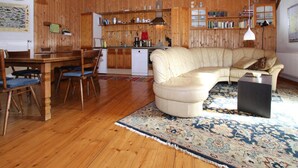 A cozy wooden interior with a dining area, a sofa, and a kitchen. - Ferienhaus, Zahrensdorf (Kloster Tempzin)