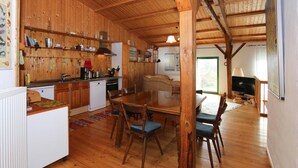 A wooden interior with a kitchen, dining area, and a television. - Ferienhaus, Zahrensdorf (Kloster Tempzin)