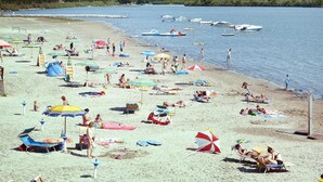 A beach with numerous umbrellas, sun loungers, and people relaxing. - Bungalow in the Residence Belvedere in Grado (Aquileia)