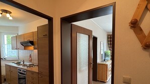 Eine moderne Küche mit Holzausstattung, einem Herd und einem Fenster mit Blick ins Grüne.