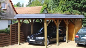 A covered carport with a black car parked inside. - Ferienwohnung, Tambach-dietharz (Tambach-Dietharz)