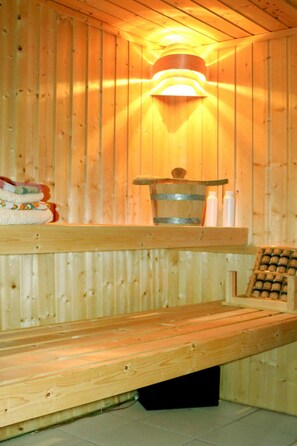 A wooden sauna with a bench, a bucket, and bottles on a shelf. - Ferienwohnung, Tambach-dietharz (Tambach-Dietharz)