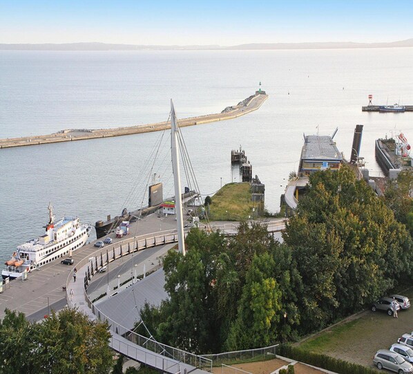 A coastal area with a cable-stayed bridge, a ferry dock, and a lighthouse in the distance. - Ferienwohnung, Sassnitz (Sassnitz)
