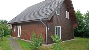 A single-story wooden house with a sloped roof, a front door, and a small porch area. - Ferienhaus Barbara, Zarrentin (Zarrentin am Schaalsee)
