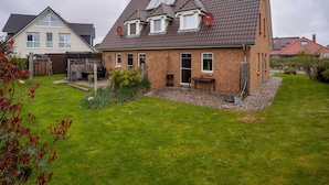 A two-story house with a sloped roof, solar panels, and a brick exterior. - Doppelhaushalfte in St. Peter-ording (St. Peter-Ording)